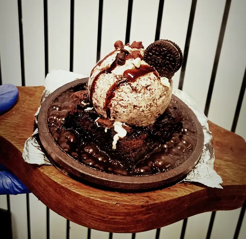 A sizzling Brownico brownie topped with ice cream, chocolate sauce and a cookie